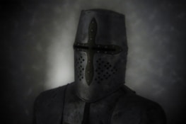 A medieval knight wearing a full face helmet stands against a dark, murky background. The helmet features a prominent cross-shaped design with small ventilation holes near the mouth area. The armor is made of metal and appears worn, with a slightly matte finish.