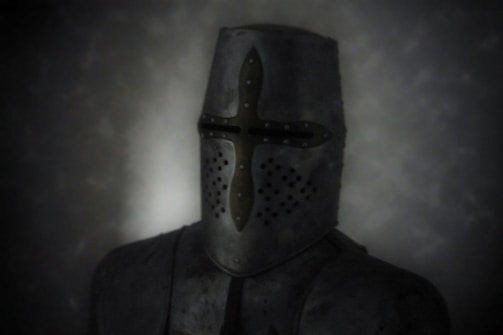 A medieval knight wearing a full face helmet stands against a dark, murky background. The helmet features a prominent cross-shaped design with small ventilation holes near the mouth area. The armor is made of metal and appears worn, with a slightly matte finish.