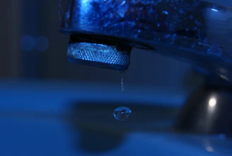 Close-up of a dripping faucet being repaired by a professional.