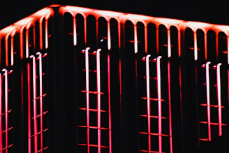 Close-up of a building facade featuring sharp angles and glowing neon outlines.