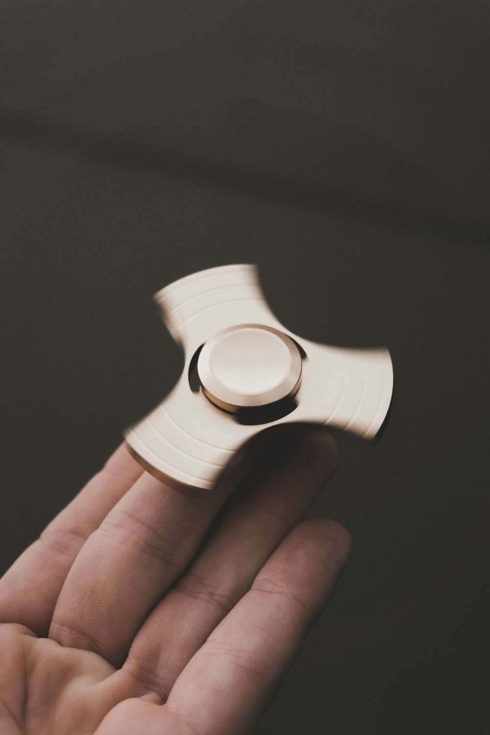 person holding brown 3-blade fidget spinner