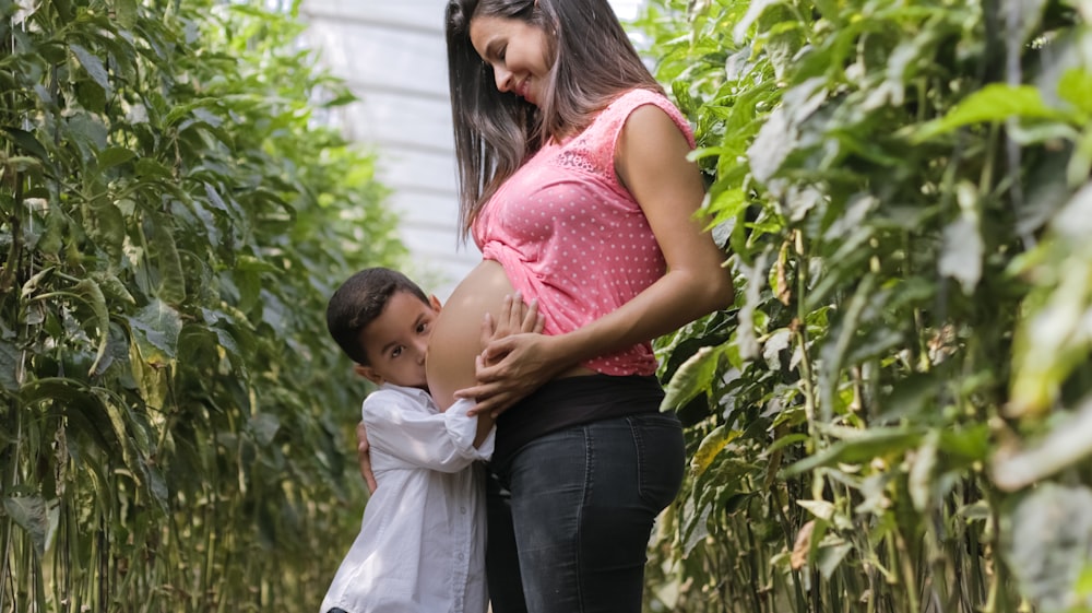 mujer embarazada y niño de pie al aire libre