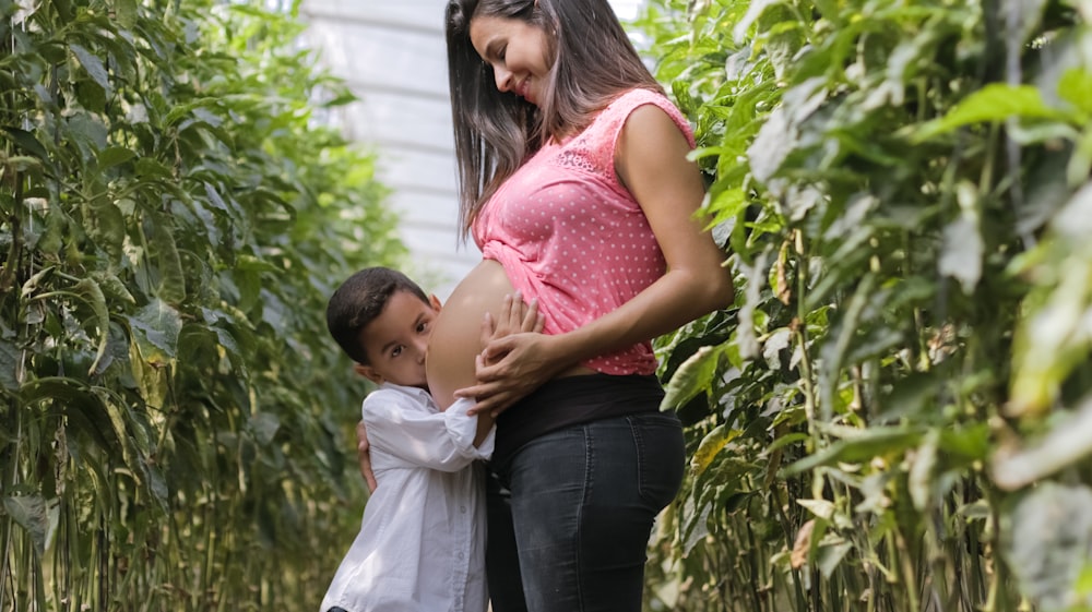 femme enceinte et enfant debout à l’extérieur