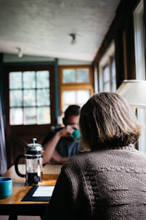 A cozy morning scene with twinroots founders enjoying coffee together at a sunlit kitchen table.
