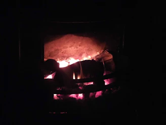 A Goodman gas furnace glowing warmly inside a cozy living room.