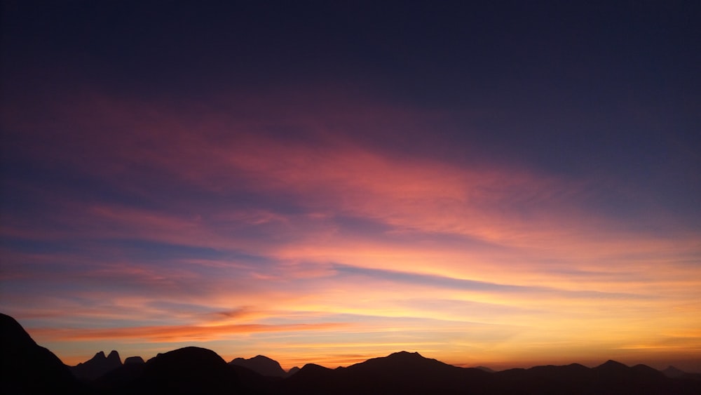 silhouette of mountains under calm sky