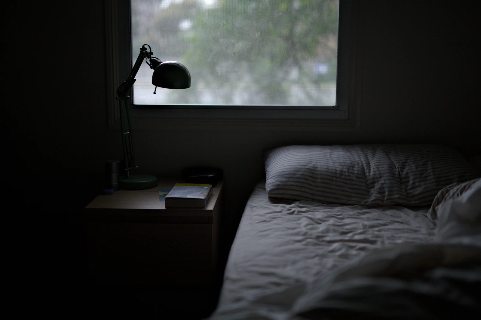 Wohnbereich einer eingerichteten Wohnung mit Bett, Sofa und Pendelleuchten