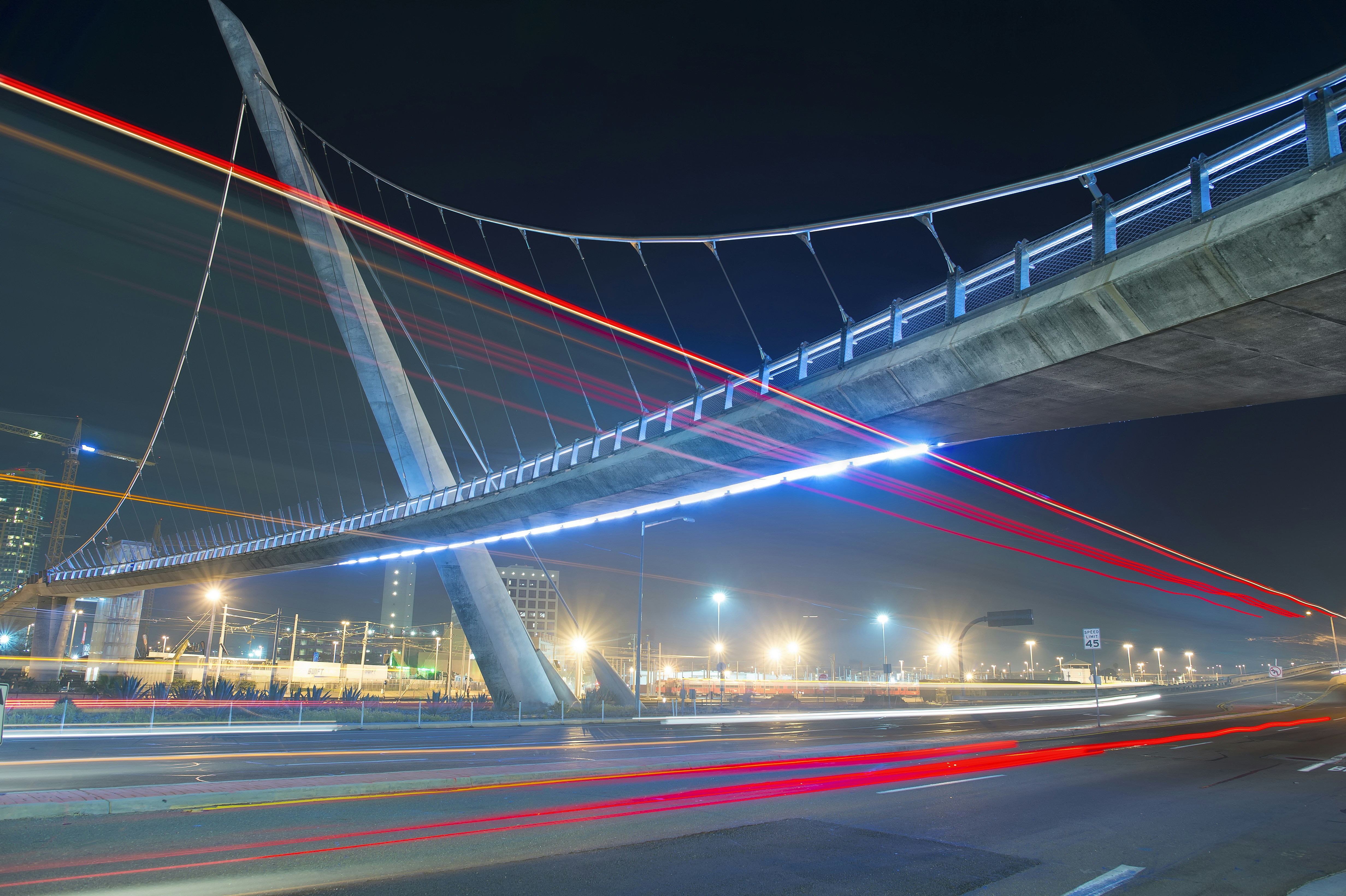 time lapse photography of vehicles under concrete bridge at nighttime