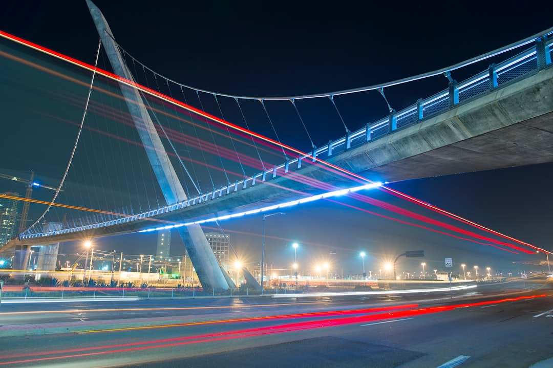 time lapse photography of vehicles under concrete bridge at nighttime