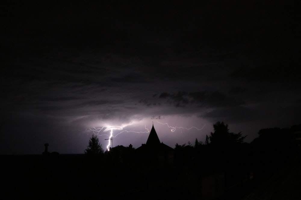 Blitzeinschlag auf Grundstück in der Nähe eines Gebäudes in der Nacht