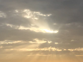 A heavenly pathway through clouds with golden rays shining down, symbolizing Chacko’s arrival in the family’s celestial reunion.