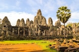 Ancient ruins of Ayutthaya temple surrounded by lush greenery under a clear blue sky.