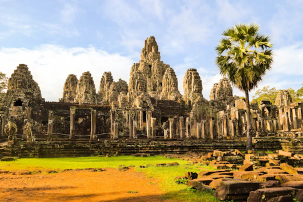 Ancient temple ruins framed by lush green jungle under a clear blue sky.