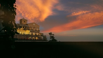 A panoramic shot of a completed masonry building standing proudly against a sunset.