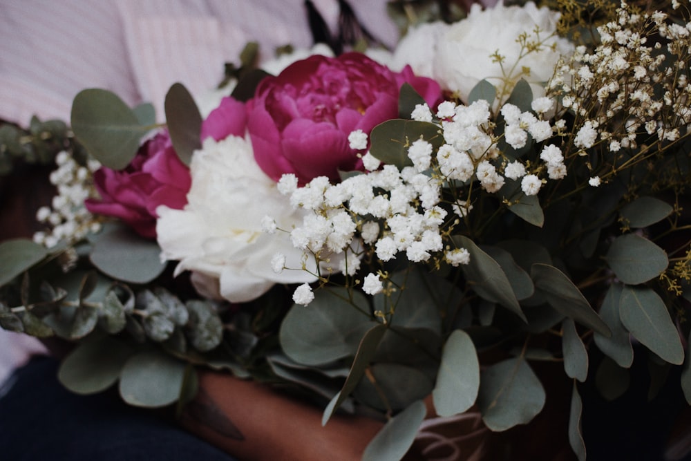 a bouquet of white and pink flowers and greenery