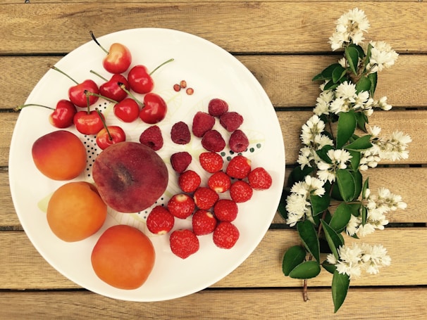 A clean dining table set with fresh fruits and a small hygiene reminder card.
