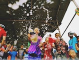 A group of young people laughing and hydrating together at an urban event with branded water bottles.