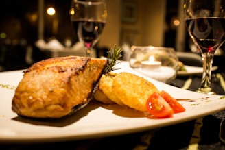 A beautifully plated continental dish featuring grilled salmon with seasonal vegetables under soft, warm lighting.