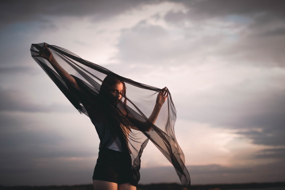 woman holding black silk garment during daytime