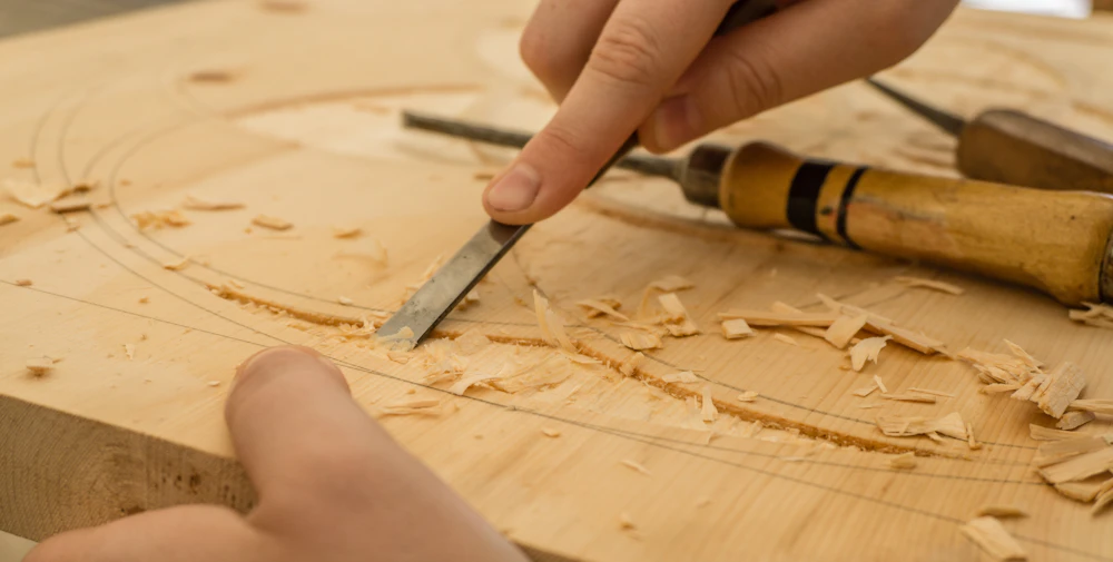 Woodworker carving a piece of wood with a chisel