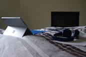 A calm, blue-themed workspace with a laptop open to mattress reviews.