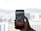 A hand holding a smartphone displaying a map application with a red location pin on the screen. The background features a blurred view of a cityscape with buildings and hills under a cloudy sky.