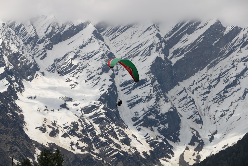 person paragliding above snowy mountains during daytime