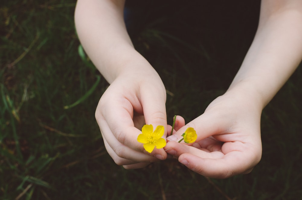 Person mit gelben Blumen