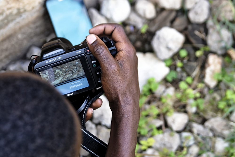 person taking a photo of Samsung smartphone using DSLR camera