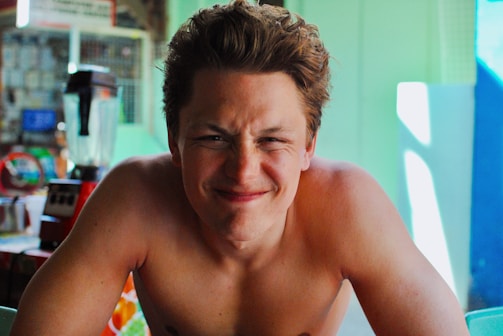 A smiling creator filming a short product video in a bright, casual setting.