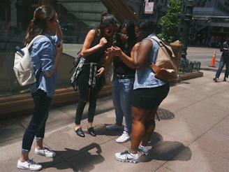 A group of girls aged 8-19 laughing and walking together on a sunlit city street, showcasing camaraderie.