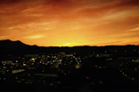 Sunset over Monterrey's Cerro de la Silla with city lights beginning to glow.