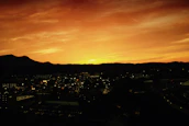 Sunset view of Monterrey's iconic mountains with colorful city lights beginning to glow.