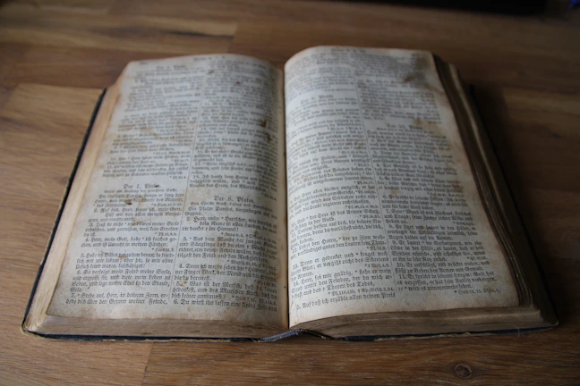 Close-up of a worn book cover with elegant serif typography on a wooden desk.