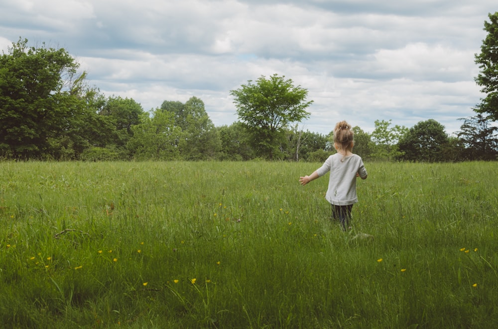 girl wearing white shirt on green grass