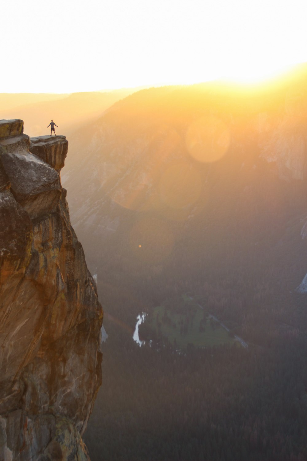 Silueta de la persona de pie en el acantilado durante la puesta del sol