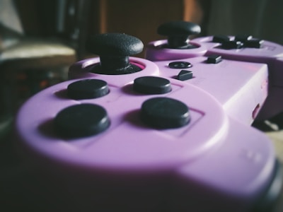 Close-up of a retro pixelated game controller in dark purple and black tones.