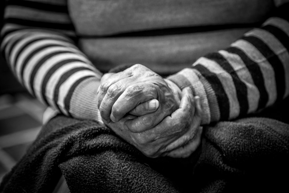 Photographie en niveaux de gris d’une personne assise