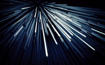 Abstract light sculpture featuring dynamic, futuristic glowing tubes in a dark room