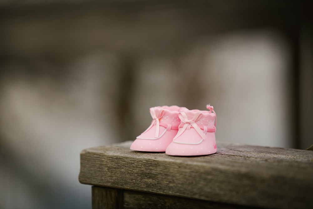 Photographie sélective de chaussures roses sur un banc en bois