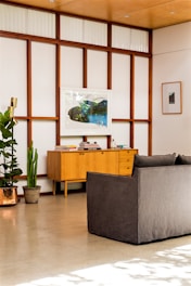 A modern living room showcasing sleek wood paneling and custom-built furniture.