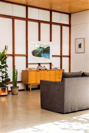 Luxurious modern living room with custom wood paneling and minimalist furniture in neutral tones.