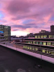 Balcony view capturing a vibrant cityscape at sunset.