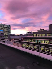 Balcony view capturing a vibrant cityscape at sunset.
