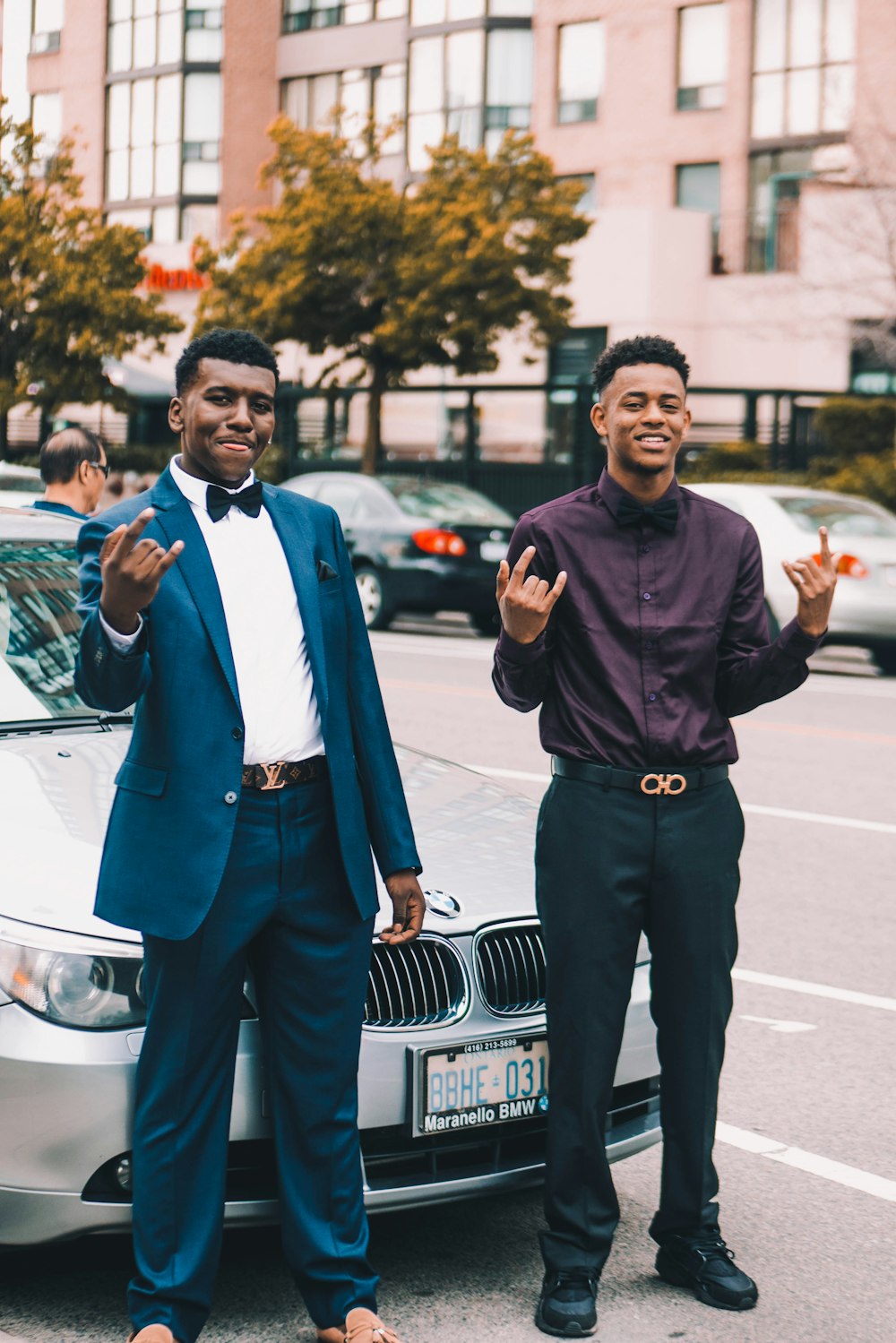 dois homens parados na frente do carro BMW