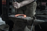 Close-up of a blacksmith shaping glowing steel with traditional tools.