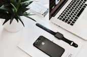 A peaceful workspace with a plant, stationery, and a digital device showcasing a productivity tool.