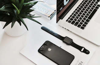 A cozy workspace with a laptop displaying tech articles and gadgets scattered around.