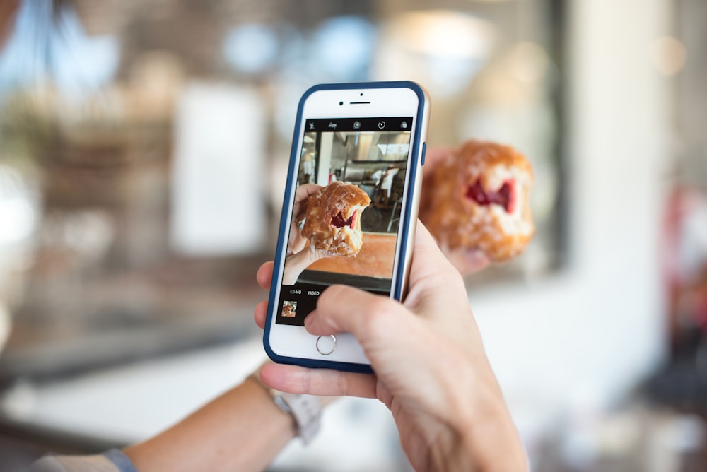 Fotografía de enfoque selectivo de la persona que toma la foto de la comida marrón