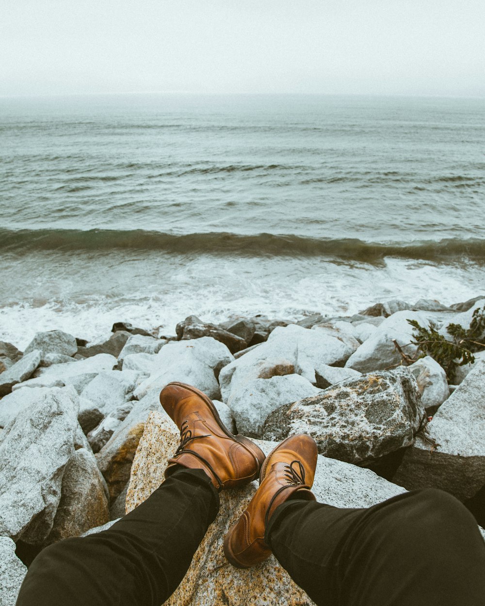 person sitting front of seashore